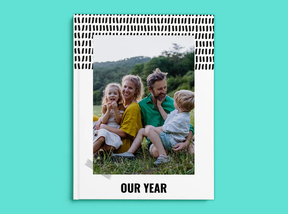 Fotoboek hardcover A4 staand op een turquoise achtergrond, vormgegeven met een familiefoto en met de titel “Our Year” op de kaft.