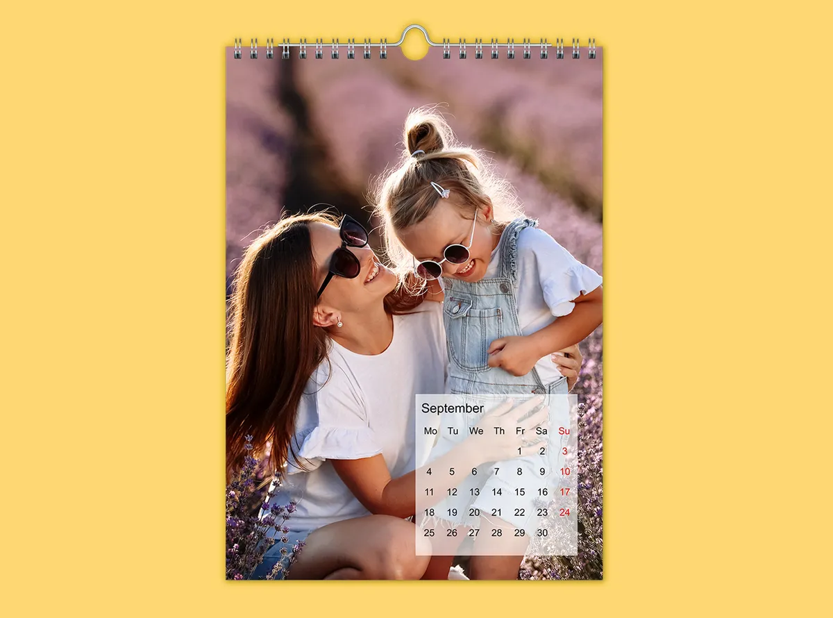 Wandkalender A4 staand op een gele achtergrond, vormgegeven met een foto van een moeder en haar dochter.